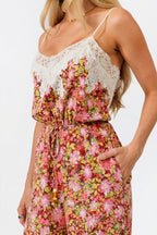 Woman wearing a floral jumpsuit with lace details on a white background