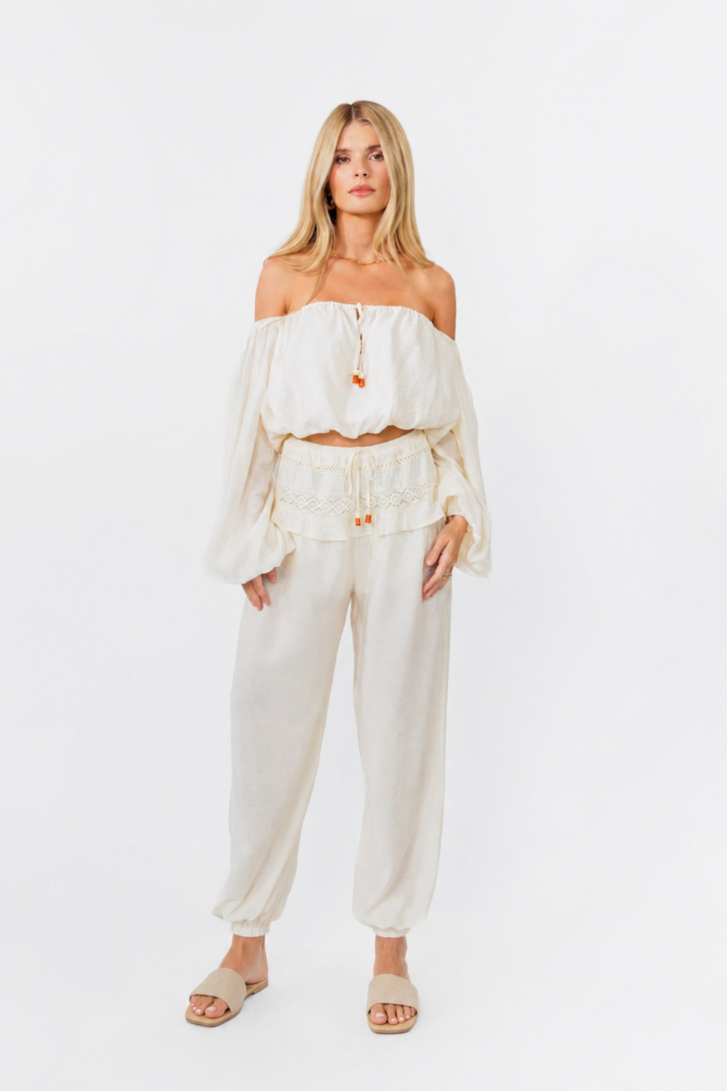 model wearing white off shoulder top with balloon pants