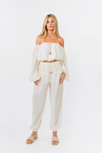 model wearing white off shoulder top with balloon pants