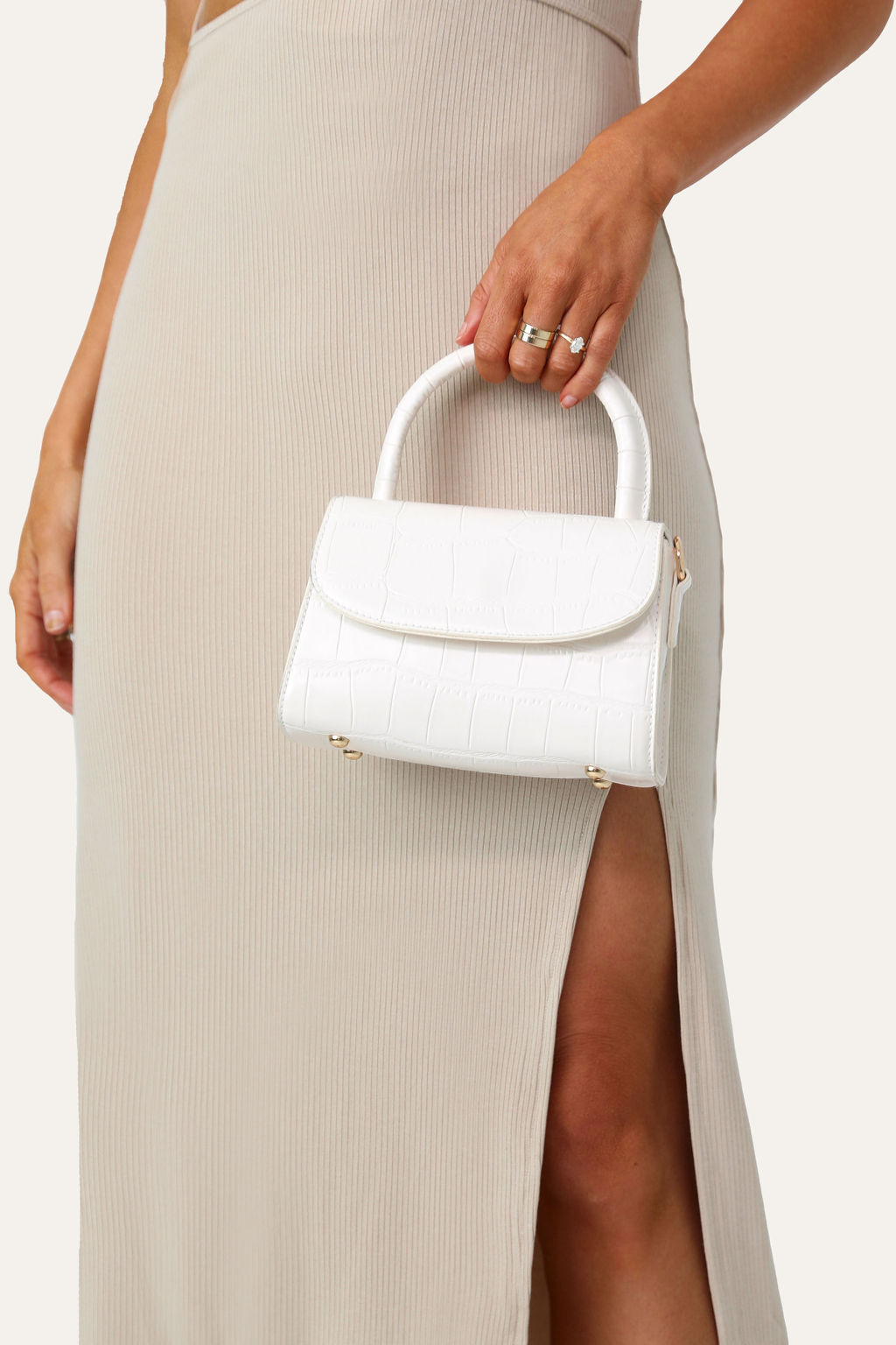 Model holding the White Micro Purse, front angle.