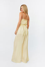 Woman wearing a light yellow dress against a white background