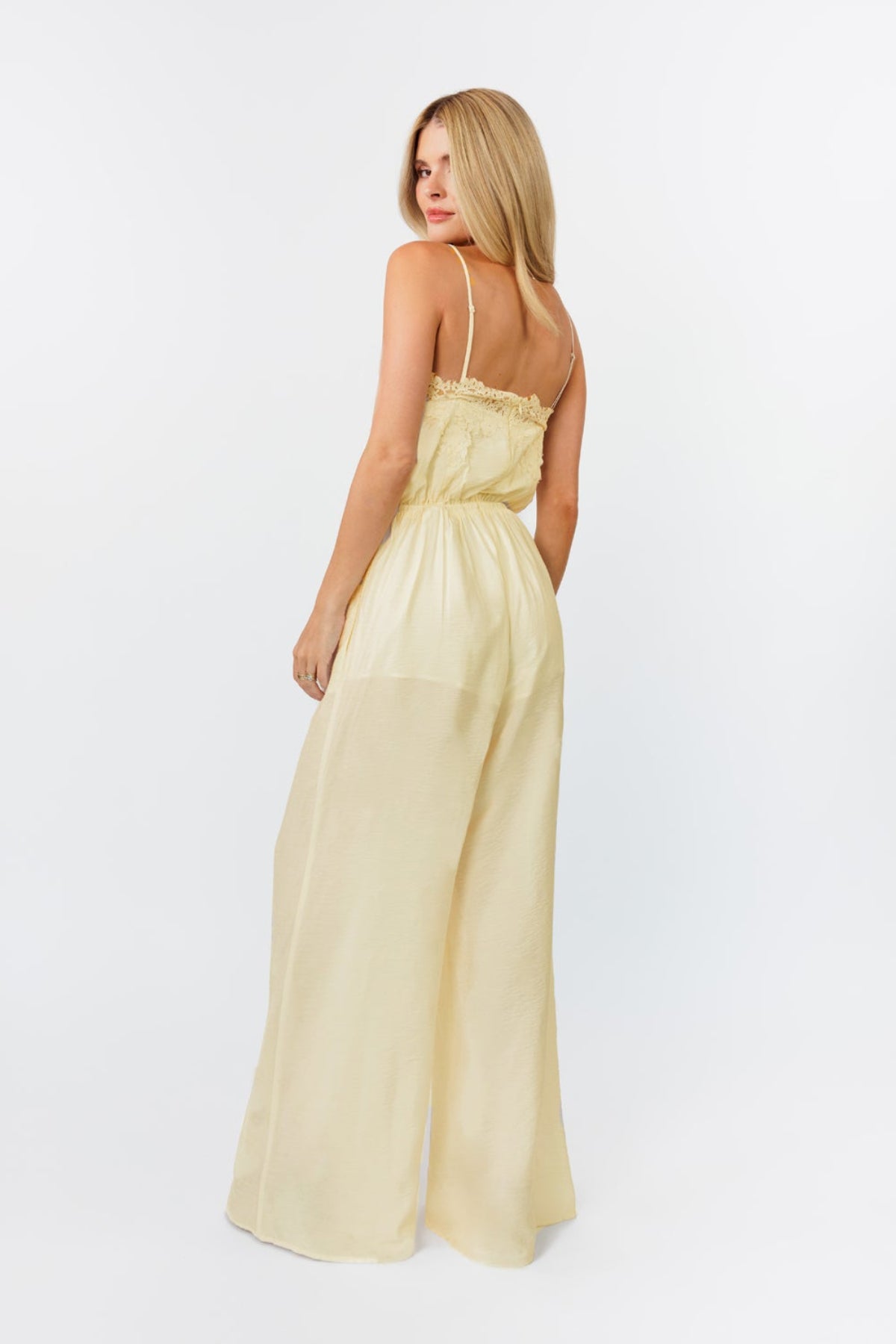 Woman wearing a light yellow dress against a white background