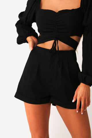 Close up front view of model wearing the Manhattan Black shorts, paired with the Doll Face Blouse.