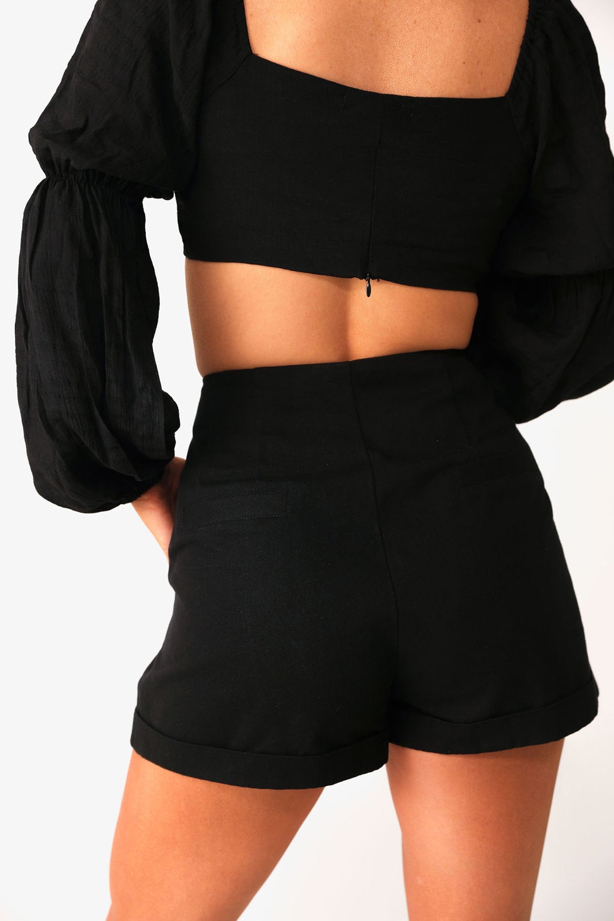 Close up back view of model wearing the Manhattan Black shorts, paired with the Doll Face Blouse.