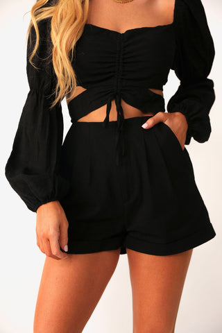 Close up front view of model wearing the Manhattan Black shorts, paired with the Doll Face Blouse.