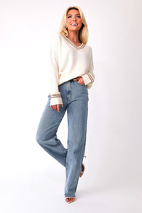 Front view of model wearing the Kylia v-neck sweater front tucked into the Beau high-rise denim jeans.