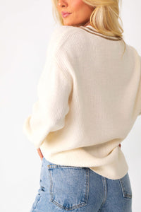 Back view of model wearing the Kylia v-neck sweater paired with the Beau high-rise denim jeans.