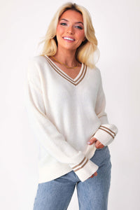 Front view of model wearing the Kylia v-neck sweater  paired with the Beau high-rise denim jeans. 