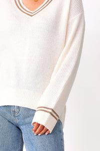 Front view of model wearing the Kylia v-neck sweater paired with the Beau high-rise denim jeans.