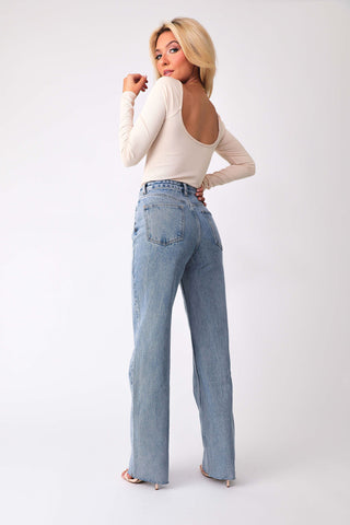 Back view of model wearing Keep It Flirty corset bodysuit, paired with Beau high-rise denim jeans.
