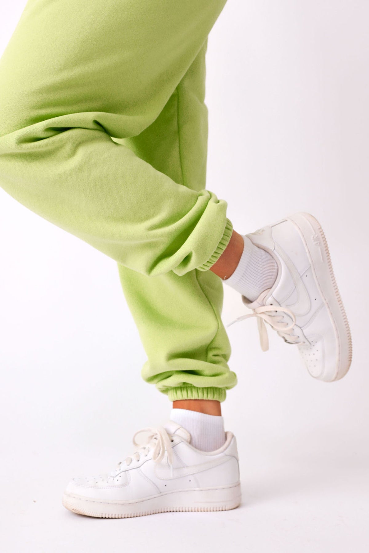 Close up side view of elasticated leg opening on KiKi joggers. Shown styled with white sneakers. 