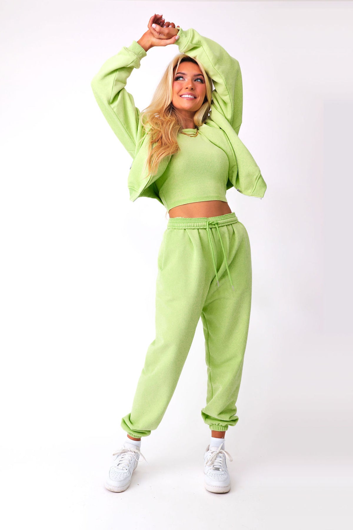 Front view of model wearing green KiKi Joggers, paired with matching KiKi full zip and razorback tank.