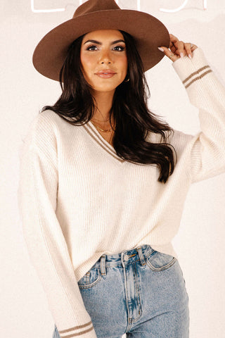 Front view of model wearing the Kylia v-neck sweater paired with the Beau high-rise denim jeans.