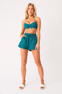 Full body front view of model wearing the Cool Breeze Linen shorts with the On The Rocks bandeau top.