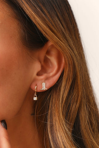 Model's ear, showcasing 10MM LOCK CUBIC HUGGIE HOOP - gold lock with cz stones