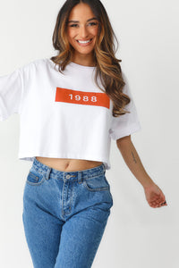 Model showcasing white oversized, crop tee with Red Block featuring "1988"