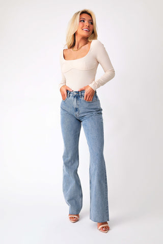Front view of model wearing Keep It Flirty corset bodysuit, paired with Beau high-rise denim jeans.