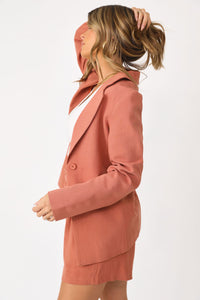 Close up side view of model wearing the Dine Me shorts paired with the Wine me blazer, and white basics tank.