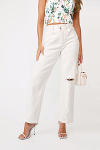 Front view of model wearing the Mallorie Asymmetric white denim jeans and In The Vineyard top.