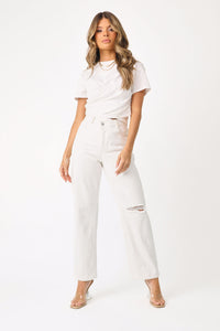Full body front view of model wearing the Tipsy Twist front shirt and Mallorie Asymmetric jeans.